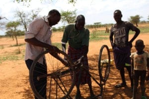 Ugandan people fixing a bicycle
