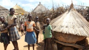 Ugandan residents outside their huts