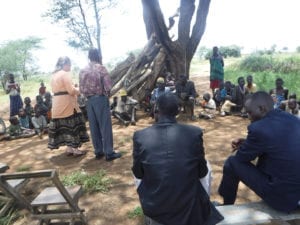 Ugandan adults and children having lessons outside