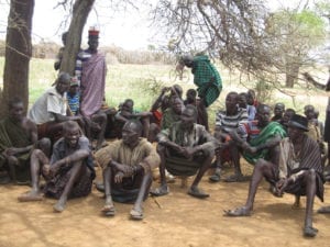 Ugandan community members seated together on the floor